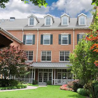 A beautiful brick building with a well-maintained garden and lush greenery.