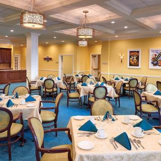 A well-appointed restaurant dining room with neatly arranged tables and chairs, featuring elegant place settings.