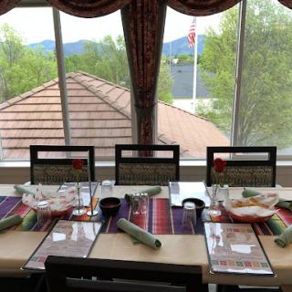 A beautifully arranged dining table with a scenic mountain view.