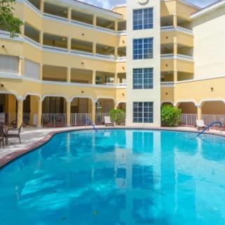 Outdoor swimming pool in front of a modern apartment complex.