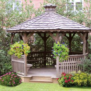A wooden gazebo surrounded by lush greenery and vibrant flowers in a garden setting.
