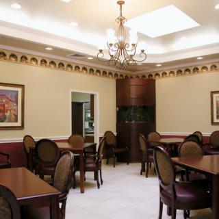 An elegant dining room with classic decor and a central chandelier.