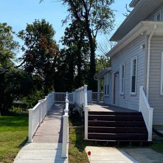 A ramp and stairs leading to the side entrance of a house.