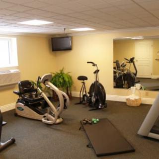 A home gym setup with various exercise equipment, including a stationary bike and treadmill.