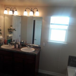 A well-lit bathroom with double sinks and a large mirror.