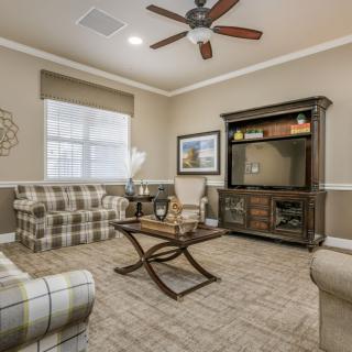 A cozy living room with plaid sofas, a wooden coffee table, and an entertainment cabinet.