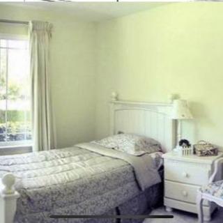 A cozy bedroom with a neatly made bed and a bright window.