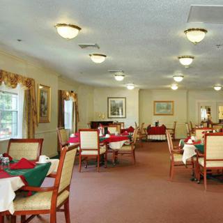 A spacious dining room with neatly arranged tables and chairs, featuring elegant decor and warm lighting.