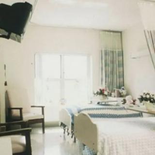 A clean and well-lit hospital room with a bed and minimal furnishings.