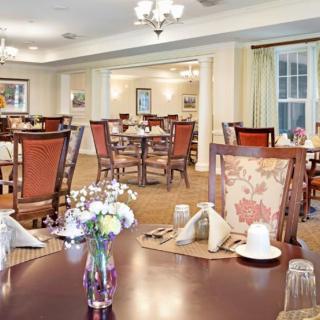 An elegantly furnished dining room with neatly arranged tables and chairs, ready for guests.