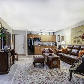 A cozy living room with elegant furniture and an open kitchen layout.