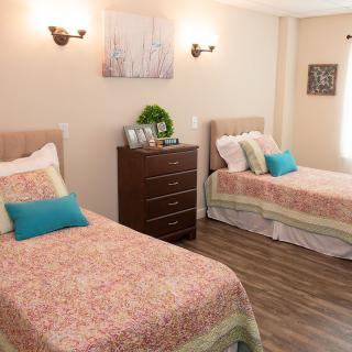 A cozy bedroom with twin beds, soft lighting, and stylish decor.