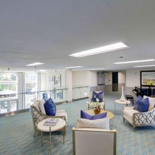 A modern lobby seating area with plush chairs and decorative cushions.