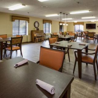An empty dining room with neatly arranged tables and chairs, featuring a warm, inviting interior.