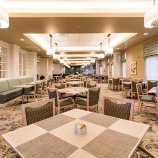 A spacious and elegantly decorated dining area with neatly arranged tables and chairs.
