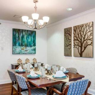 A beautifully decorated dining room with elegant artwork and a well-set table.