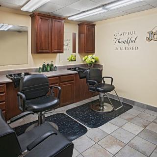 Modern hair salon interior with styling chairs, mirrors, and cabinets.