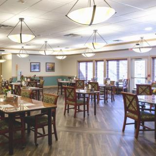 A spacious and well-lit dining area with neatly arranged tables and chairs.