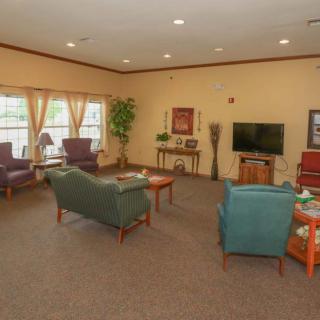 A cozy living room with sofas, chairs, a television, and decorative elements.