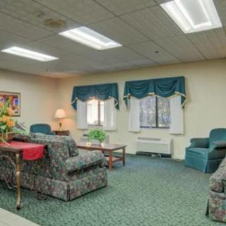 A cozy living room with sofas, a coffee table, and windows adorned with curtains.