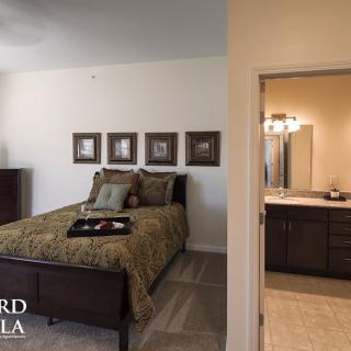 A modern bedroom with an en-suite bathroom, featuring elegant decor and furnishings.