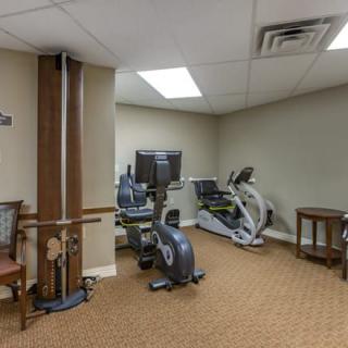 A small gym room with various exercise equipment, including an exercise bike and weight machine.