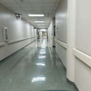 A long, well-lit corridor in a hospital showcasing a clean and orderly environment.