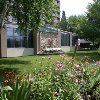 A beautiful garden with colorful flowers in front of a building.