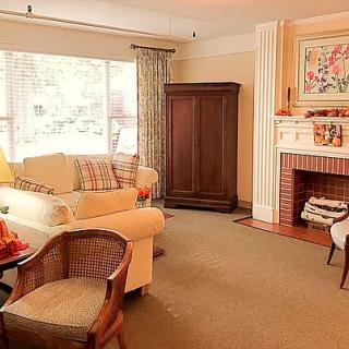 A cozy living room with a comfortable sofa, armchair, and a fireplace.