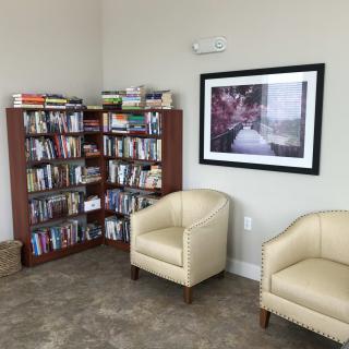 Cozy reading corner with a bookshelf and comfortable chairs.