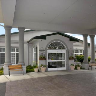 A symmetrical building entrance featuring large columns and a covered walkway.