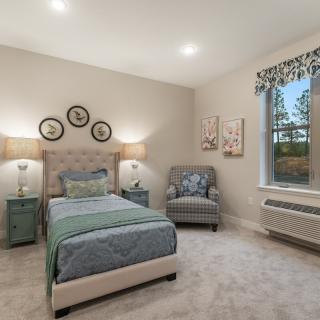 A cozy bedroom with a single bed, armchair, and stylish decor.