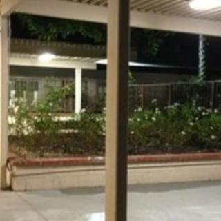 A quiet patio at night with garden lights and a fenced area.