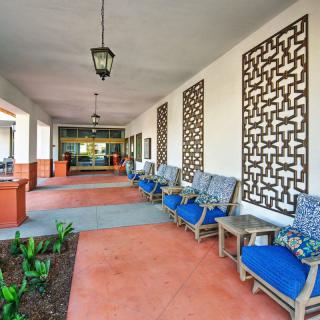 A welcoming hotel entrance with blue cushioned chairs and decorative wall panels.
