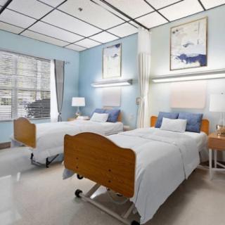 A clean, brightly lit hospital room with two patient beds and modern decor.