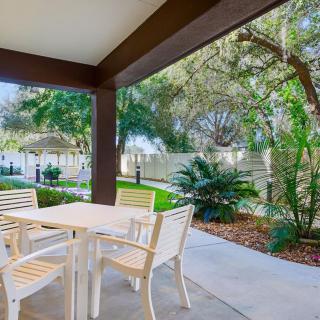 A serene patio area with a table and chairs overlooking a landscaped garden.