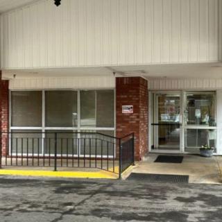 An accessible building entrance with a ramp and glass doors.
