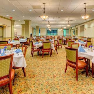 A spacious and elegantly designed dining area, ready for guests with tables set for a meal.