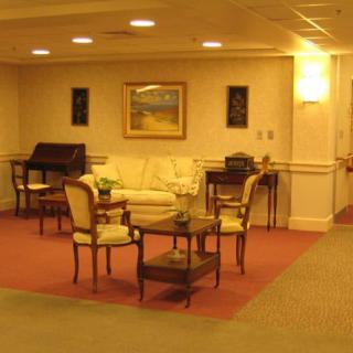 A cozy lounge area with traditional furniture and artwork on the walls.