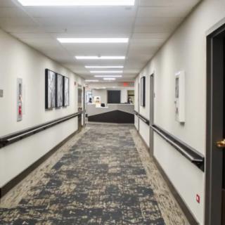 A modern, well-lit hallway with carpet and doors on either side.