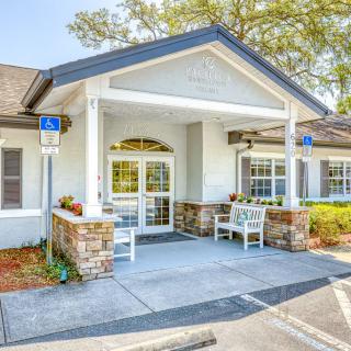A welcoming entrance of a single-story building with seating and accessible parking.
