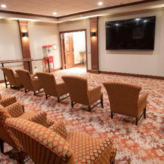 A cozy home theater setup with comfortable seating and a large screen TV.