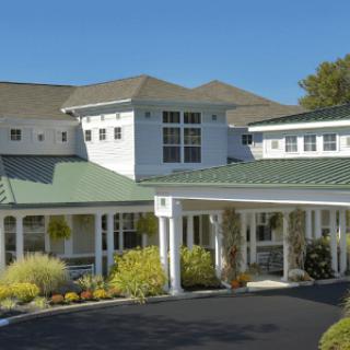 A modern residential building with a welcoming entrance under a clear blue sky.