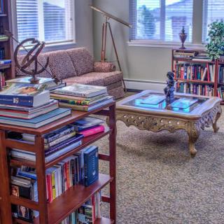 A cozy living room with bookshelves filled with books and comfortable furniture.