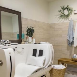A modern bathroom interior featuring a sleek bathtub, decorative plants, and neatly arranged towels.
