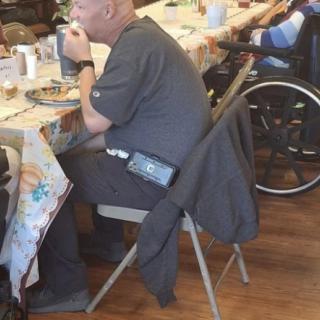 Older adults enjoy a meal together at a community dining setting.