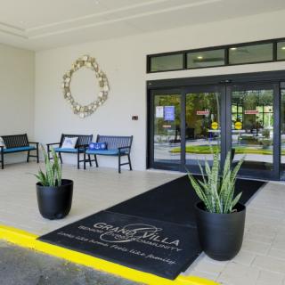 A modern building entrance with decorative plants and seating.