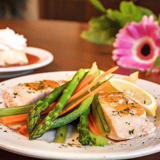 A gourmet dish featuring salmon and asparagus served with a lemon wedge.