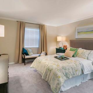 A cozy and elegantly decorated bedroom with a large bed, stylish furniture, and soft lighting.