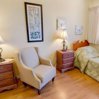 Cozy bedroom with an armchair, nightstands, and a bed.